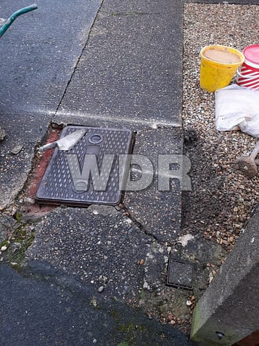 Broken concrete around manhole cover
